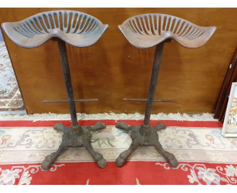 A pair of cast iron tractor type bar stools (2).