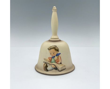 Matte porcelain tan bell with a semi-high relief of a child reading a book, and the text 1980 Maria Hummel on the other side.