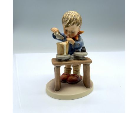 Hand-painted figurine depicting a boy using a scoop and scale to measure and weigh out an ingredient. Goebel backstamp on the