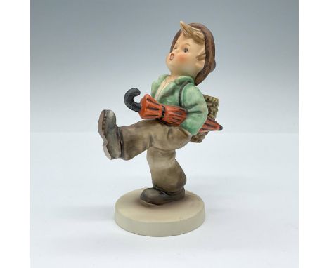 Hand painted matte finished porcelain figurine depicting a boy traveler walking with a basket on his back and an umbrella tuc