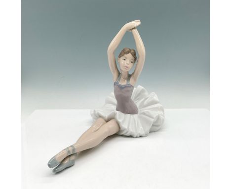 Hand painted, glazed figural in seated ballerina position, colored in gray, white and lavender. Nao by Lladro backstamp. 1208