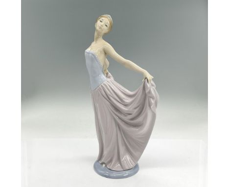 Glazed porcelain figure of a graceful dancer in a long dress holding the expanded ends of the skirt. Lladro backstamp. Artist