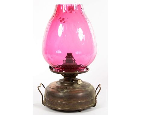 AN OXIDISED BRASS OIL LAMP WITH A DIMPLED CRANBERRY GLASS SHADE, 44CM H, ADAPTED FOR ELECTRICITY&nbsp; 