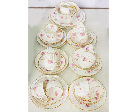 AN AYNSLEY FLUTED BONE CHINA TEA SERVICE, PRINTED AND PAINTED WITH SCATTERED GROUPS OF ROSES, THE RIMS AND HANDLES GILT, PRIN