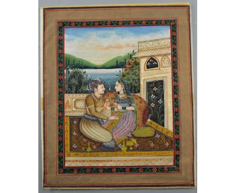 Indian miniature painting depicting a man and woman seated on a carpet on a balcony with a lake and landscape beyond, 37cm x 