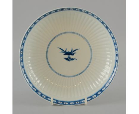 A Worcester blue and white saucer dish c1775 the reeded interior with central painted floral sprig and stylised border, open 
