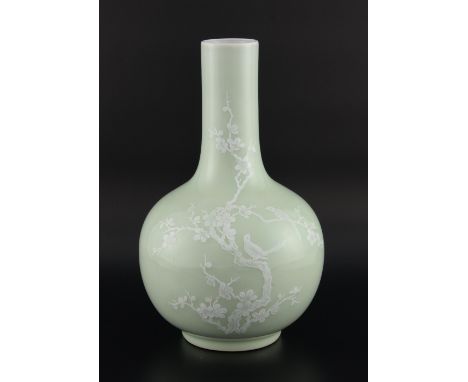 Chinese porcelain bottle vase, the pale celadon ground enamelled in white with two birds in a prunus bush, underglaze blue se