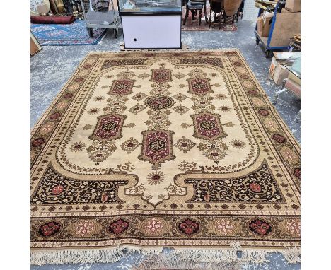 A large machine made carpet of classic Persian design.