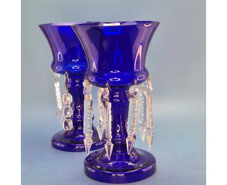 A pair of blue glass lustres, the drops hung from the base of urn shapes on waisted columns and circular feet.   H 26cms.