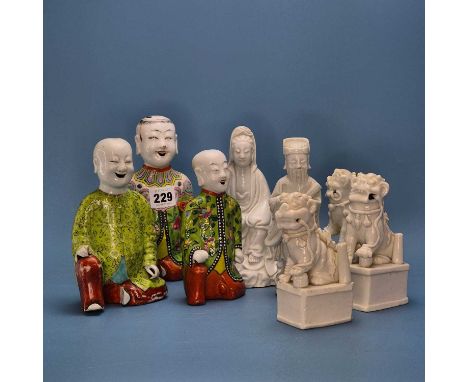 Three Chinese polychrome figural jostic holders, three blanc de Chine Buddhist lions, a blanc de Chinese figure of Guanyin an