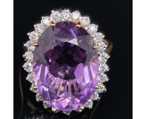 An 18ct hallmarked gold, amethyst and diamond large cluster ring. Oval amethyst weight 10.00ct, diamond weight 0.80ct. Ring s