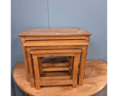 A nest of three ' Mouseman' Robert Thompson oak tables with adzed tops. 