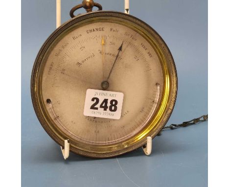 An E J Dent aneroid barometer in a glazed brass case with an alcohol thermometer at the base of the paper dial. Serial number