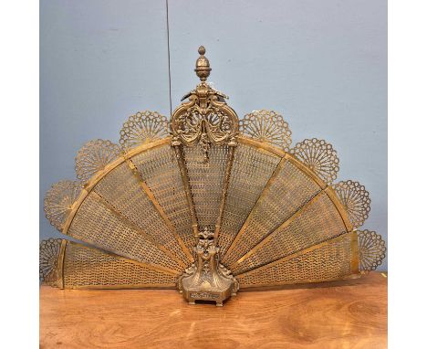 A brass fire screen of eight pierced leaves opening up into a fan shape