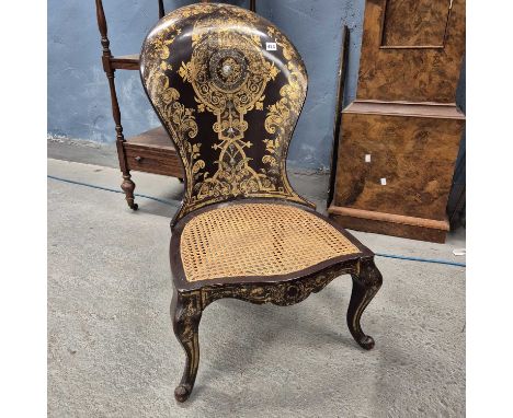 A gilt and mother of pearl inlaid papier mache chair, the spoon back above a caned seat and cabriole front legs