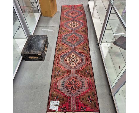 A Persian tribal hand knotted runner. 295 x 63 cm.