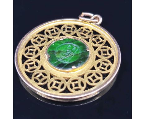 A vintage eastern character pendant the reverse set with a green disc. Unhallmarked assessed as 14ct gold. Diameter 2.8 cm. W