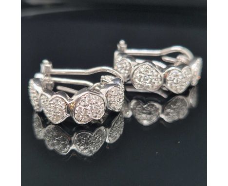 A pair of diamond set half hoop multi-cluster heart earrings, each earring with four diamond set hearts, with adjustable stem