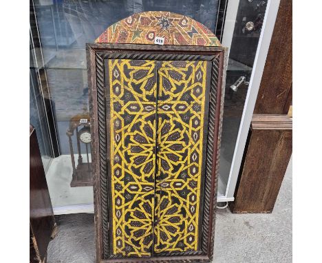 An Islamic window shutter, the doors painted in yellow with rosettes and geometrics between barley twist pilasters below roun