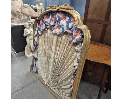 A gilt framed half tester bed head, the ogee front with foliage and scrolls, a fan of mushroom coloured textile within the fr