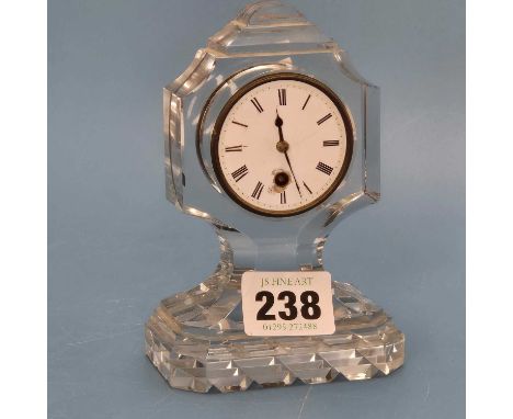 A glass cased pendulum driven timepiece, the enamel circular dial raised in the case above a hobnail cut rectangular foot.   