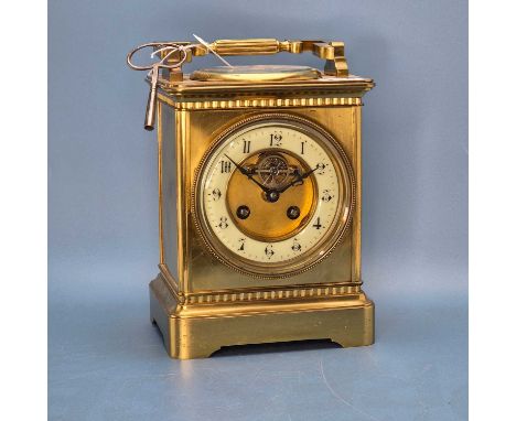 A French brass cased clock striking on a coiled rod, the top handle over a compass and mercury thermometer, the chapter ring 