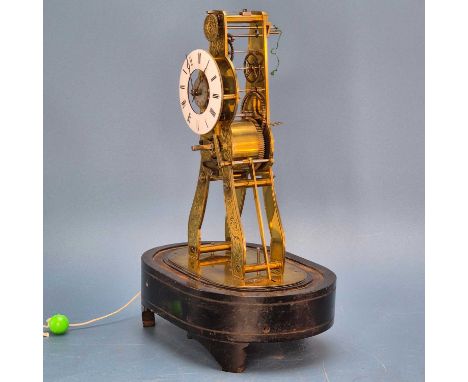 A skeleton alarm clock under a glass dome, the bell within the ebonised base, the enamel dial enclosing the silvered alarm se