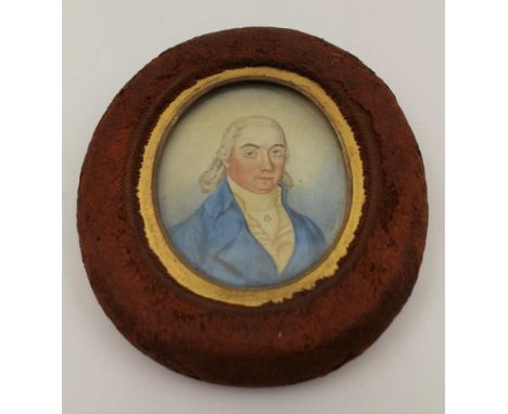 A 19TH CENTURY MINIATURE PORTRAIT PAINTING, gentleman in a blue coat, his cravat pinned with a heart clasp, 7cm x 6cm, in wor