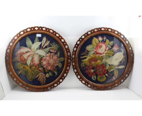 A PAIR OF 19TH CENTURY ROSEWOOD FRAMED WOOLWORK TAPESTRY PANELS, floral designs with roses and lilies, the panels 44cm in dia