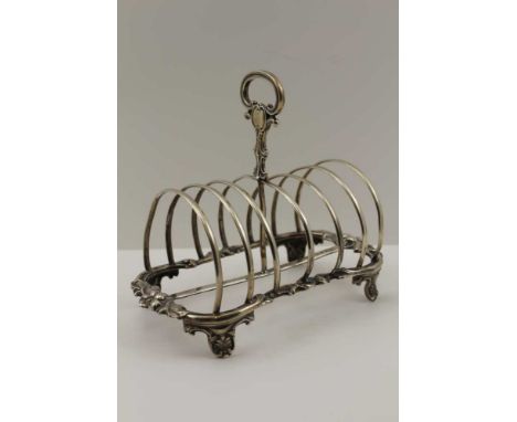 HENRY WILKINSON &amp; CO A MID-19TH CENTURY SILVER TOAST RACK, having floral cast frame, central hoop handle, raised on press