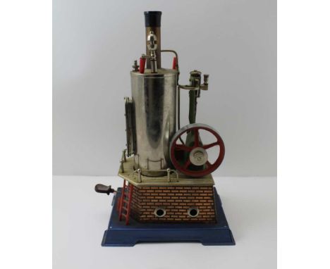 A WILESCO STATIONARY STEAM ENGINE, piston driven fly wheel on brick effect tin base and blue platform, bears label "Wilesco m