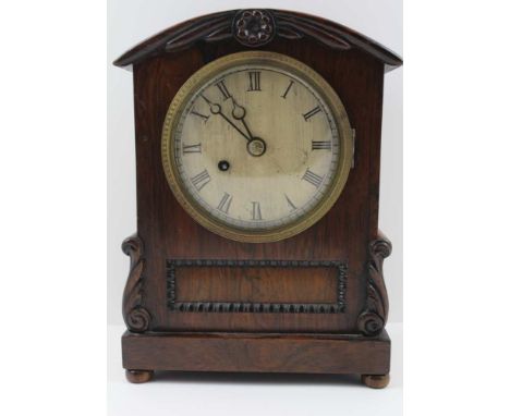 A 19TH CENTURY ROSEWOOD CASED MANTEL CLOCK, the arch top with floral design, the base with acanthus scroll detail raised on b