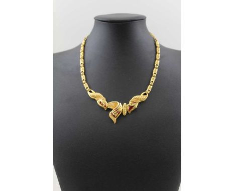 AN INDIAN GOLD NECKLACE of hinged scroll form, with red enamel detail, on a graduated fancy link chain, weight 48g, in a "Kha