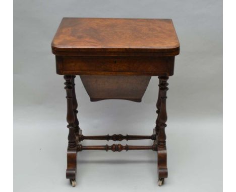 A VICTORIAN WALNUT GAMES / WORK TABLE having foldover revolving top, revealing checkerboard, backgammon and crib, over a sing