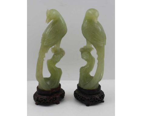 A PAIR OF CHINESE CARVED JADE HO-HO BIRDS, perched pose, 17cm high, together with carved hardwood stands 