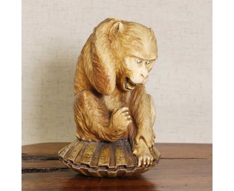 A Japanese ivory okimono,Meiji period (1868-1912), carved with a monkey seated on a large clam,16cm highIMPORTANT NOTE This l