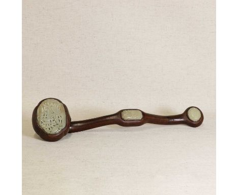 A Chinese ruyi sceptre, 20th century, the wood handle inset with shaped jade panels carved with scrolls, 49cm longWood with s