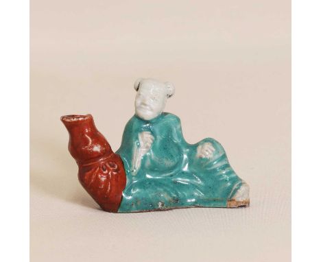 A Chinese porcelain whistle, Republic period (1912-1949), of Li Bai in a green robe, seated by a double gourd vase, 8.5cm lon