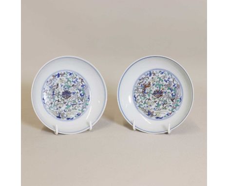 A pair of Chinese doucai saucers, 19th-20th century, the rounded sides rising from a circular foot, enamelled with stylised p