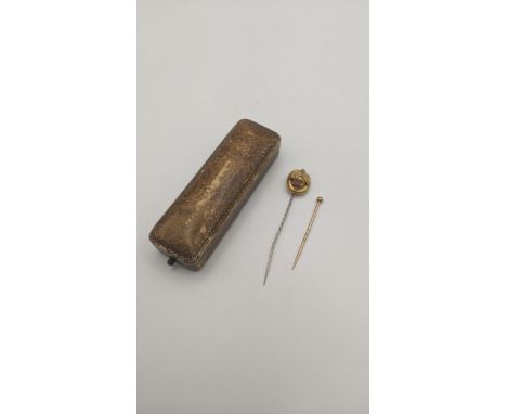 Two gold stick pins to include one set with amethyst coloured stones with a later pin, and one other, both tested as 14ct gol