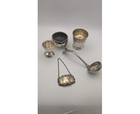 Silver to include a decanter label, salts A/F, ladle and eggcup, along with a white metal pot having an engraved floral borde