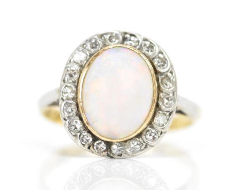 An 18ct yellow gold and platinum opal and diamond cluster ring, the central oval opal surface measurements approx 10.4mm x 8.
