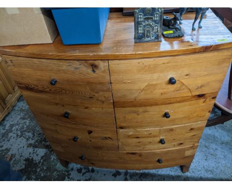 A pitch pine bow fronted chest of six short drawers, over one long drawer, ebonized handles on block feet 114cm x 105.5cm x 4