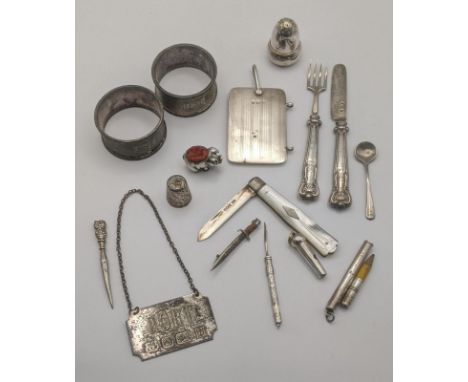 silver to include a decanter label, tooth pick, whistle, note book and pepper pot along with a white metal pin cushion fashio
