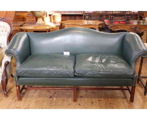 Green studded leather arched back settee on square moulded legs, 194cm long.