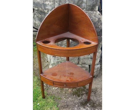 A 19th century mahogany corner wash stand, the top with spaces for wash jug and bowl, the lower shelf with drawer, height 42i