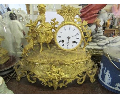 A gilt mantle clock, surmounted by Putti