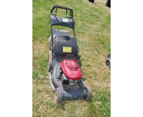 A Honda petrol engined lawn mower, no grass collector. Engine turns - no fuel cap.