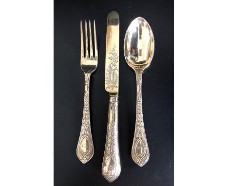 HIGHLY DECORATIVE VICTORIAN SILVER GILT KNIFE, FORK AND SPOON,all with raised foliate decoration to the handles and engraved 