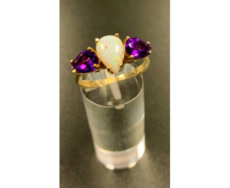 UNUSUAL OPAL AND AMETHYST THREE STONE RINGthe central pear cabochon opal flanked by pear cut amethysts, on nine carat gold sh